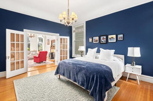 旧金山Gorgeous Victorian Flat的蓝色卧室,配有床和红色椅子