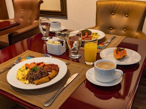 圣何塞Studio Hotel Boutique的餐桌,早餐盘和咖啡盘