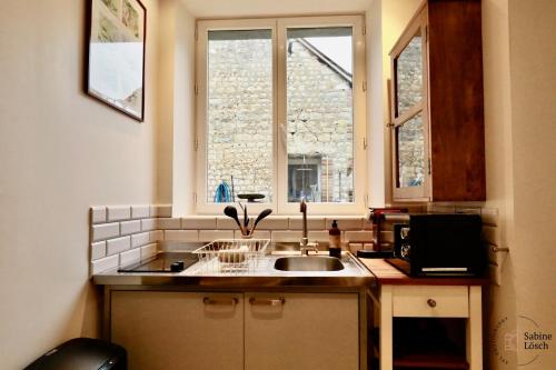 Le VaudreuilChez Marcel的厨房设有水槽和窗户。