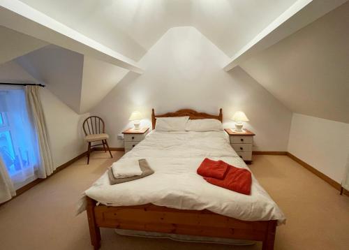 巴林托伊Main Street Cottage, Ballintoy的一间卧室配有一张带2个床头柜的大床