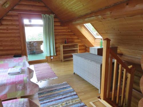 Saunaga külalistemaja, Tartust 9km kaugusel的小木屋内的一个房间,配有一张床和一个窗户