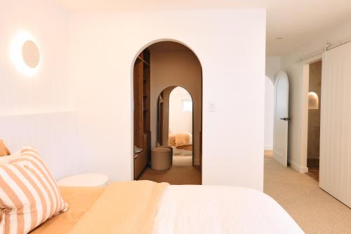 巴利纳Entre Palmas Ballina的卧室配有白色的床和拱门