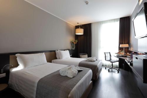 热那亚贝斯特韦斯特酒店CHC机场店的酒店客房设有两张床和电视。