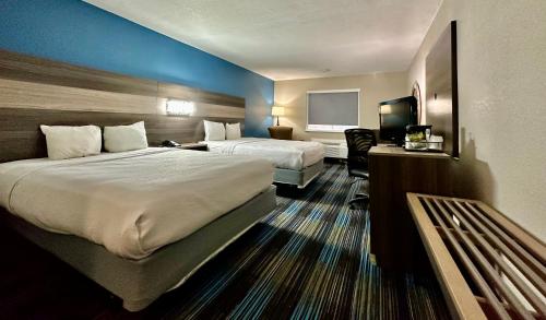 堪萨斯城Baymont by Wyndham Kansas City KU Medical Center的酒店客房设有两张床和电视。