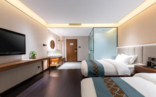 北京唐府中式文化酒店-南锣鼓巷店的酒店客房设有两张床和一台平面电视。