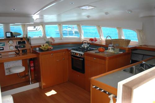 圣安尼Catamaran TAO的厨房配有木制橱柜和船上的炉灶