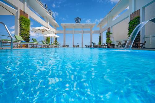 岘港钻石海酒店的一个带椅子的酒店游泳池和一个游泳池