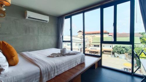 查汶J4 Samui Hotel - SHA Plus的一间卧室设有一张床和一个大窗户