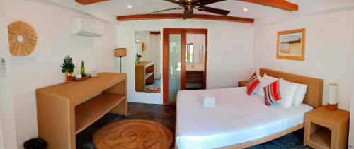 卢纳将军城Tropical Temple Siargao Resort的一间卧室配有一张床和一张书桌