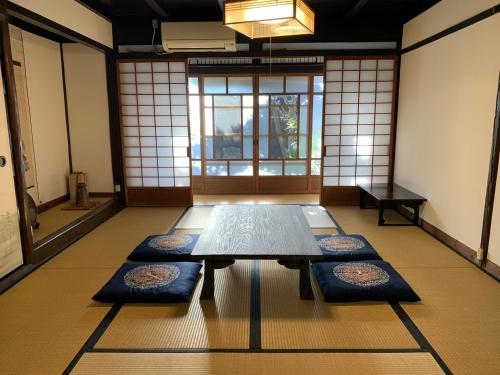 近江八幡市Guesthouse Shin的一间地板上配有桌子和垫子的房间