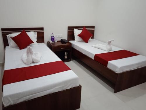 古瓦哈提HOTEL HAREN GRAND的两张床铺,位于酒店客房内,配有天鹅