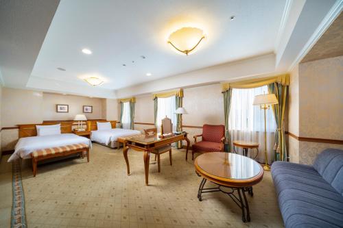 名古屋KOKO Hotel Nagoya Sakae的酒店客房,设有两张床和一张沙发
