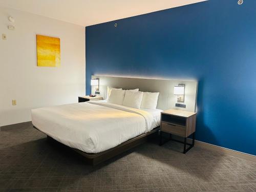 WylieComfort Inn & Suites Wylie的一间卧室设有一张蓝色墙壁的大床