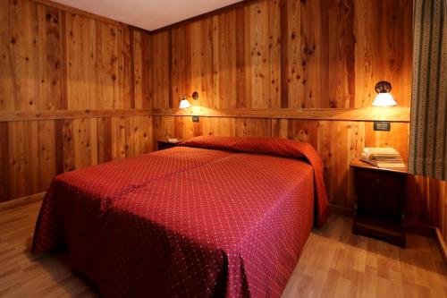 布吕松Valley Vacanze的一间卧室设有红色的床和木墙