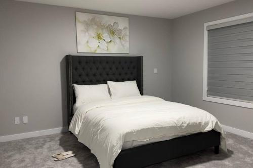 埃德蒙顿3 Bedroom Single Family Home的一间卧室配有一张大床和黑色床头板