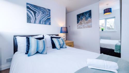 WervinNewhall Road - 4 Bedroom Chester Home - Parking的一间卧室配有一张带蓝色和白色枕头的床