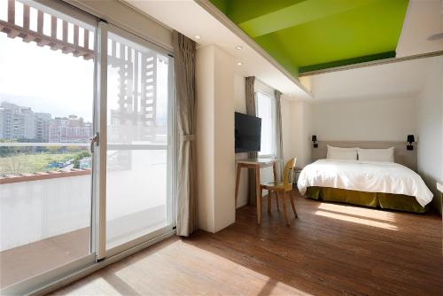台北阳光士林珮柏旅馆的一间卧室设有一张床和一个滑动玻璃门