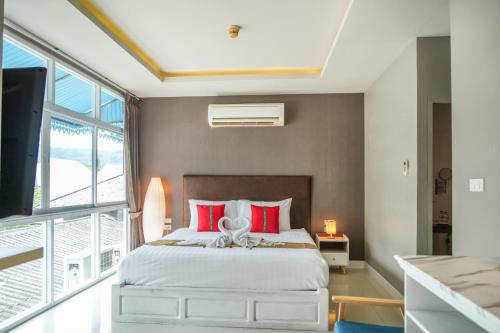 查汶Lenny's Koh Samui的一间卧室配有一张带红色枕头的大床