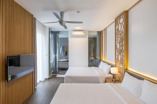 顺化Moon Sun Boutique Villa Hotel的酒店客房设有两张床和一台平面电视。