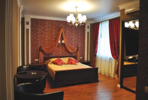 SarapulHotel Staraya Bashnya的一间卧室配有一张床、一张桌子和一个吊灯。