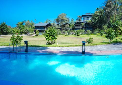 瓦亚纳德Niyatma Wayanad Premium Coffee Resort By VOYE HOMES的水中有两个灯的游泳池