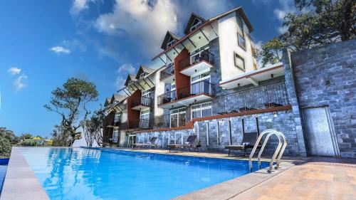 钦纳卡纳Shola Crown Resort - Munnar的大楼前设有游泳池的酒店