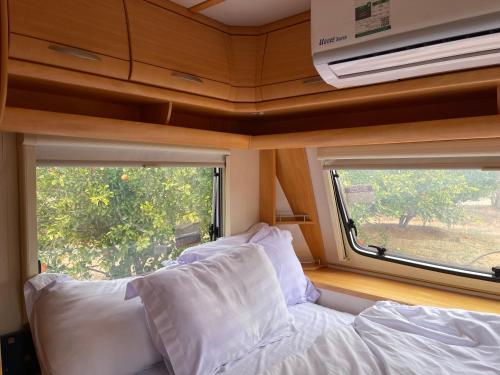 欧拉Naseem Country House的一间大篷车内的卧室,配有沙发和窗户