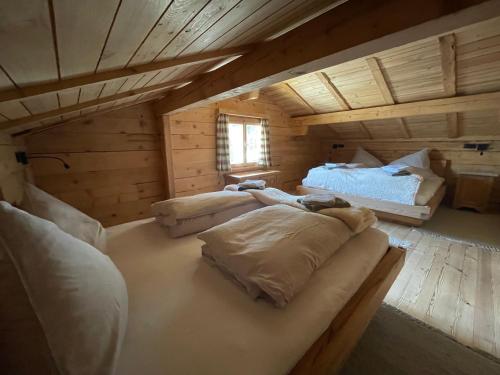 查贡斯Alpenchalet Piz Hüsli的小木屋内一间卧室,配有两张床