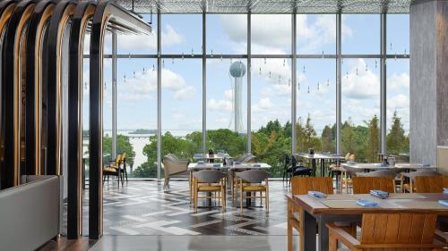 常州常州星河万丽酒店的一间带桌椅并享有塔楼景致的餐厅