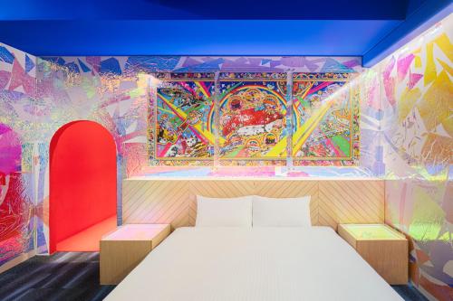 东京BnA WALL的卧室的墙上装饰有色彩缤纷的壁画