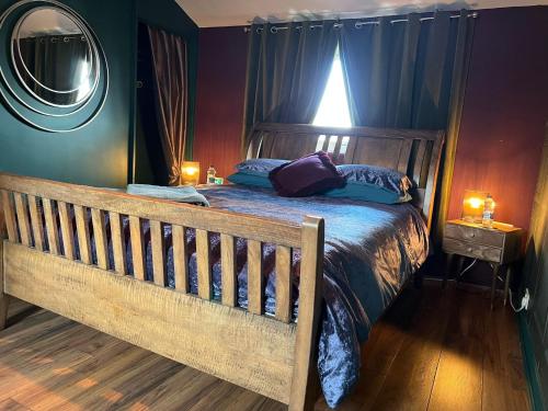 牛顿艾克利夫Jackson place的一间卧室配有一张带蓝色床单和镜子的木床