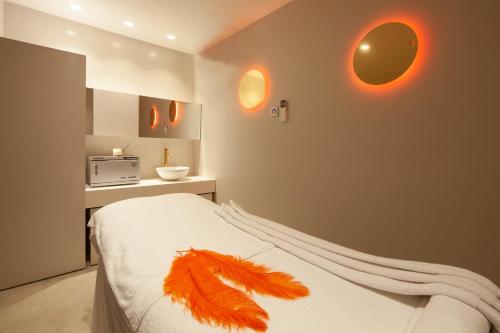 罗萨斯Hotel Montecarlo Spa & Wellness的一间卧室配有一张带羽毛的床。