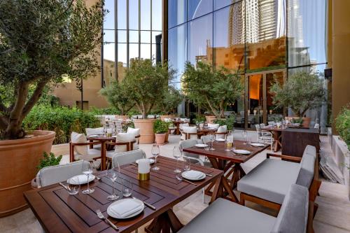 迪拜The Dubai EDITION的一间设有桌椅和树木的餐厅