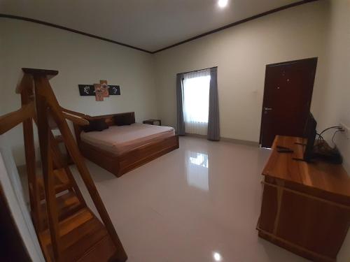 塞隆贝拉纳克kamala的一间卧室设有一张床,楼梯位于卧室内