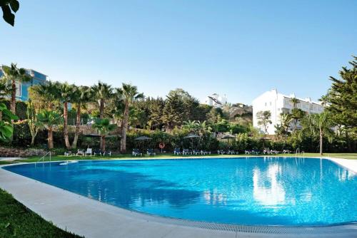 萨阿拉德洛斯阿图内斯Apartamento Costa Zahara的一个带椅子和树木的大型蓝色游泳池