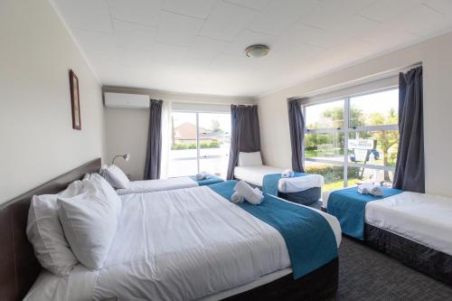 陶波Lake Breeze Motel的酒店客房设有两张床和窗户。