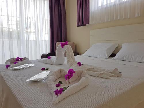 凯麦尔Agva Apart Otel的床上有毛巾和紫色鲜花