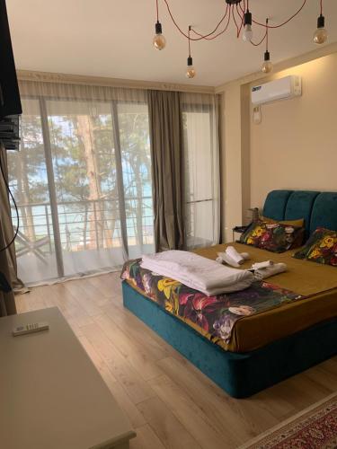 格里戈莱蒂Mana-Mana的一间卧室配有一张床、一张沙发和窗户。