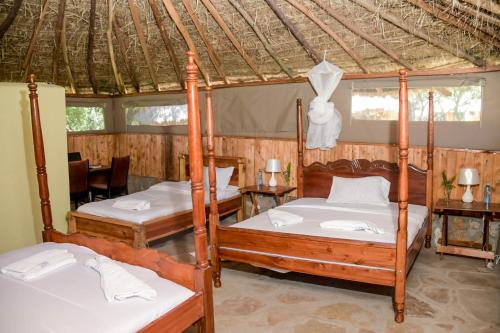 马赛马拉Giraffe Hills Mara Camp的一间带两张床和帐篷的卧室