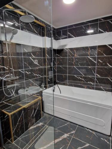 SentaFantastico Exlcusive Hotel的浴室设有黑色瓷砖墙壁和白色水槽