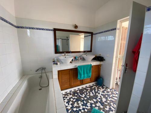 PalmarinVilla avec piscine entre plage et Siné Saloum的浴室设有2个水槽、浴缸和镜子
