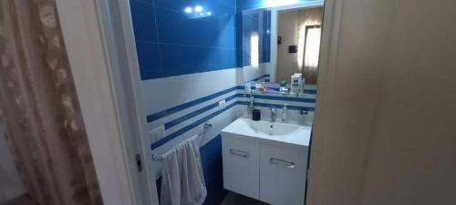 切萨雷奥港Appartamento Porto Cesareo的蓝色和白色的浴室设有水槽和镜子