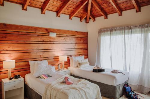 埃斯克尔埃尔克伦宾馆的一间卧室设有两张床和木墙