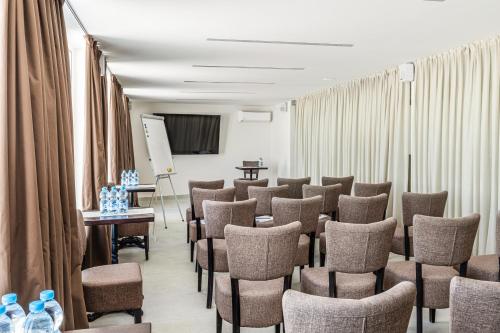 敖德萨斯科佩里设计酒店的一间房间,配有一束椅子和一个讲台