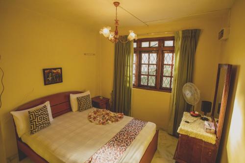 康提Jaya Tomodachi的一间卧室设有一张床和一个窗口