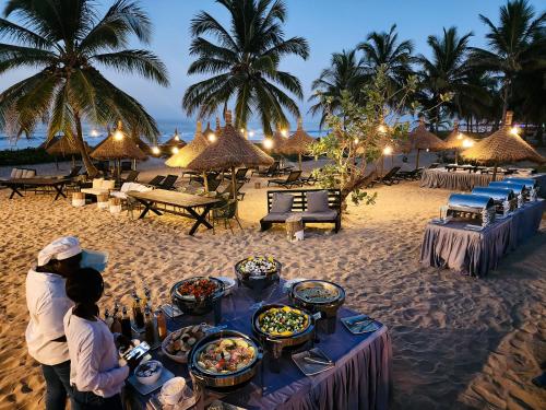 科图Tamala Beach Resort的海滩上的餐桌和食物