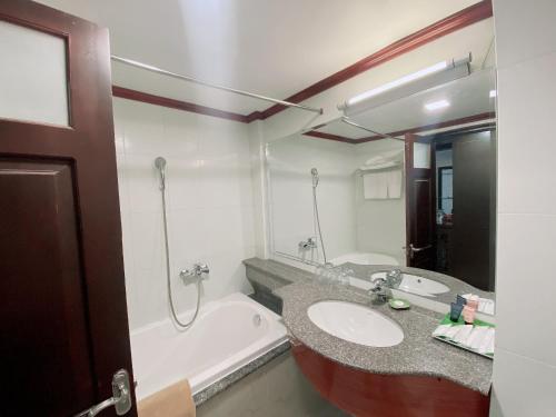 荣市Muong Thanh Thanh Nien Vinh的浴室配有盥洗盆和浴缸。