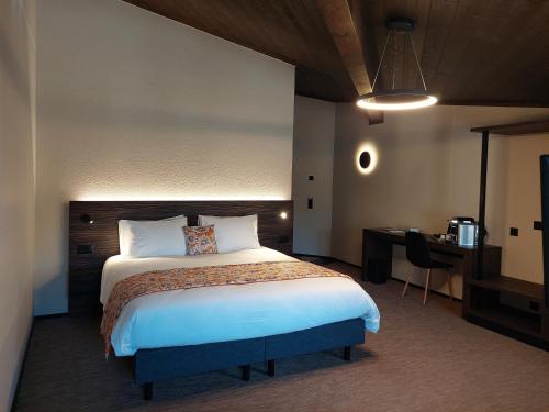 CourtedouxKza Jura Swiss的配有一张床和一张书桌的酒店客房