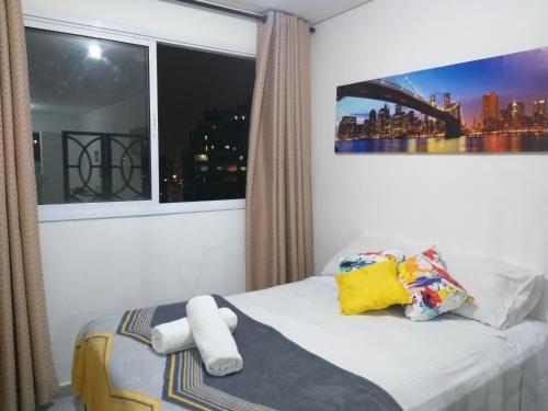 圣保罗Apartamento no centro de São Paulo的一间卧室设有窗户和一张带毛巾的床。
