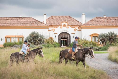 Santa CatalinaEl Colibri - Relais & Châteaux的一群人骑马在房子前